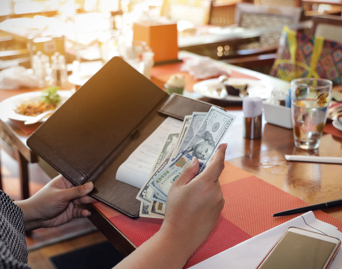 diner paying restaurant bill with cash