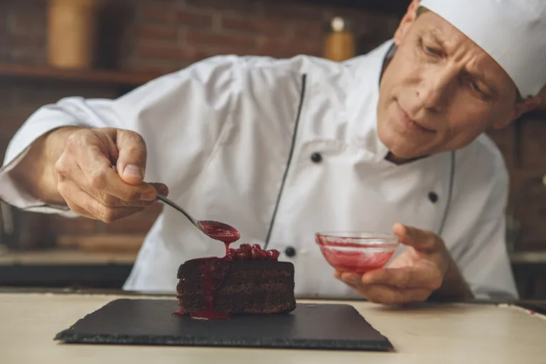 Mature male professional chef cooking meal indoors dessert