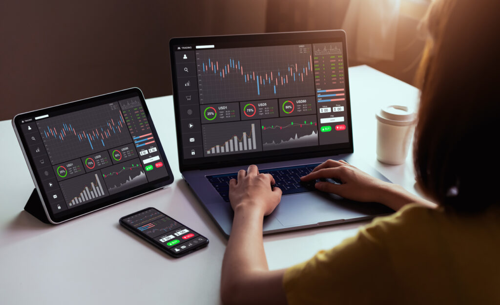 Woman looks at data analytics software on laptop, tablet, and smart phone.