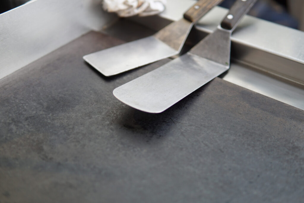 Spatula and griddle cooking tools in a professional kitchen setting ready for food preparation